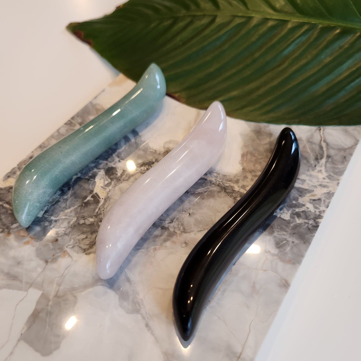 3 Crystal Wand Yoni mini with an S-Shape for internal stimulation on a marble plate
