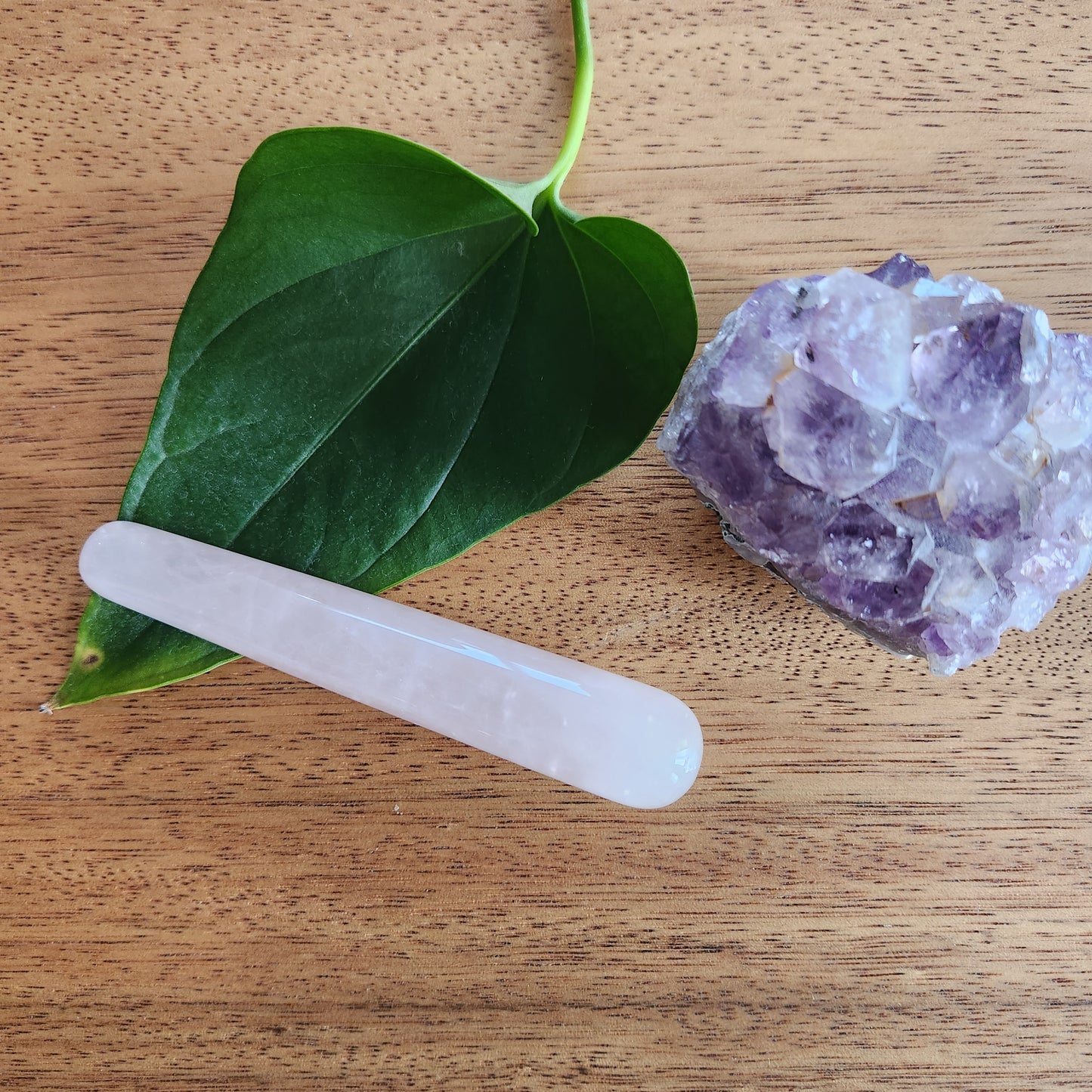 Crystal Wand Yoni mini Rose quartz in a wood surface