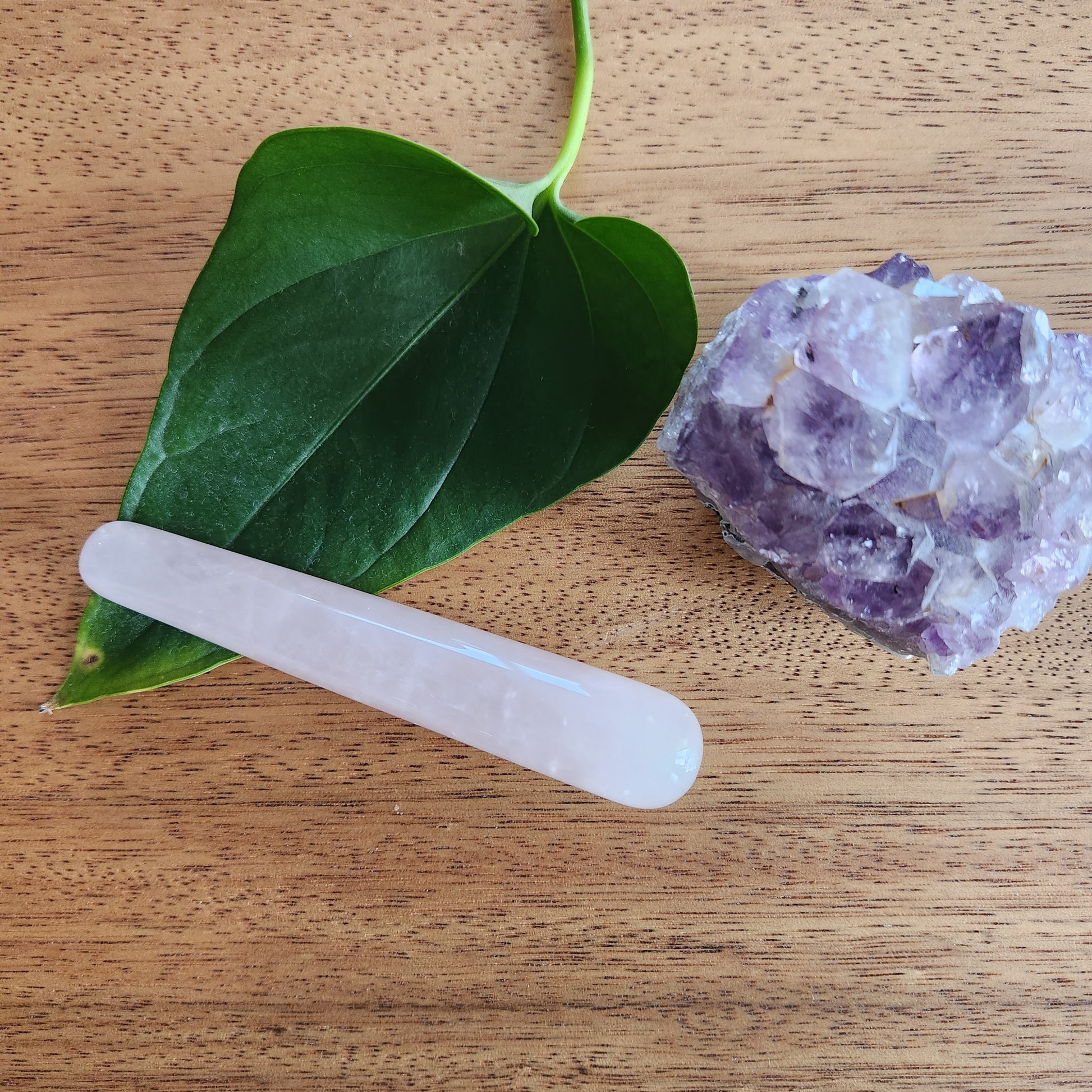 Crystal Wand Yoni mini Rose quartz in a wood surface