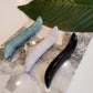 3 Crystal Wand Yoni mini with an S-Shape for internal stimulation on a marble plate