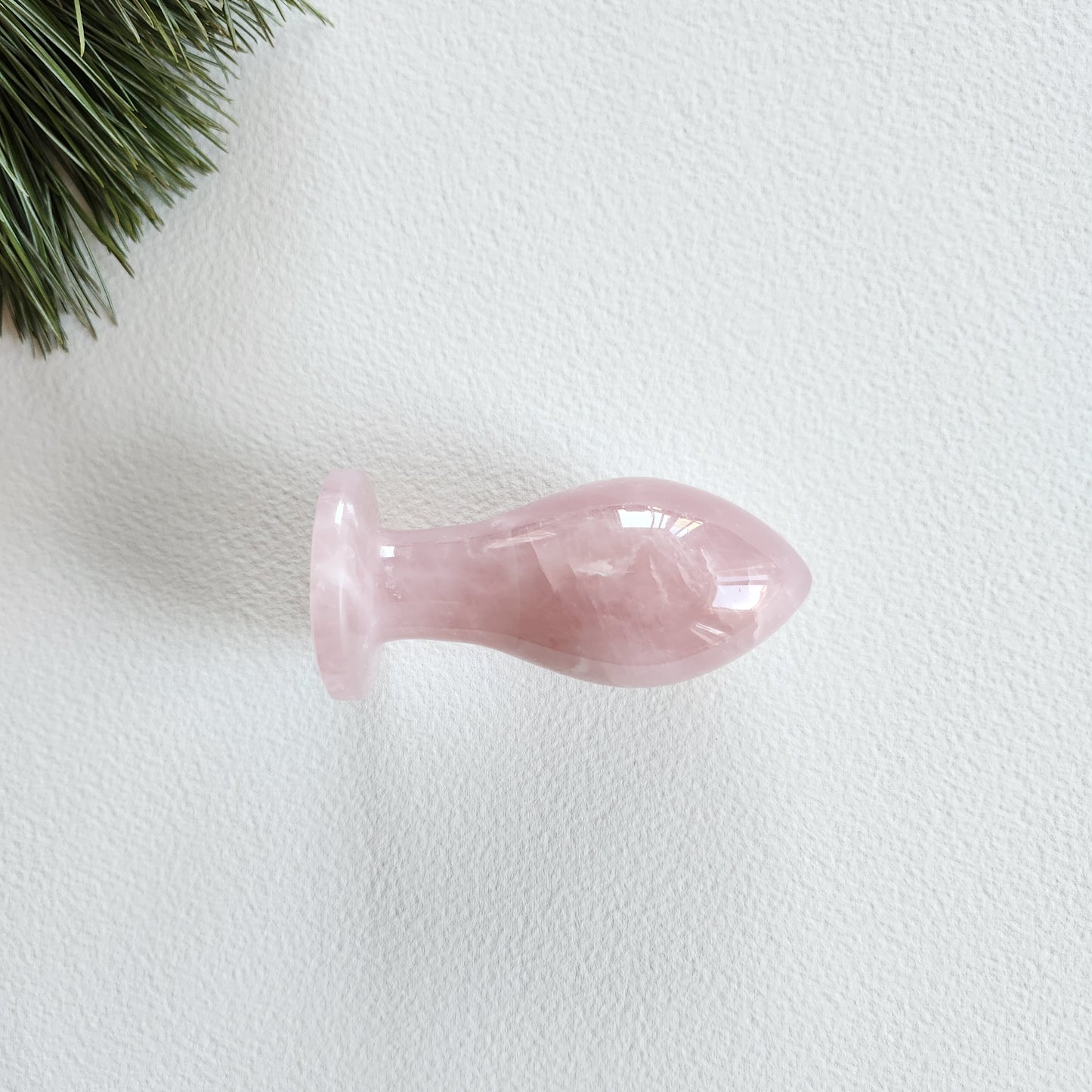 Hand-carved Rose Quartz crystal butt-plug with a smooth, polished finish for anal pleasure
