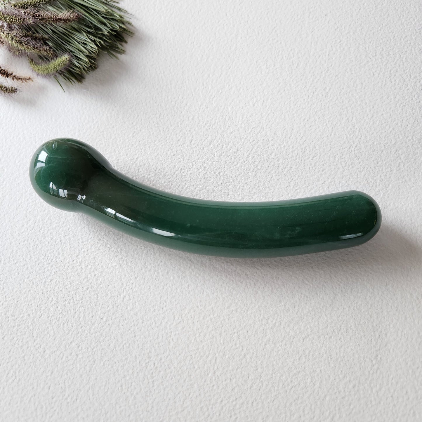 Crystal Wand Yoni Curved Green on a white surface