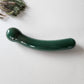 Crystal Wand Yoni Curved Green on a white surface