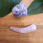 Ergonomically shaped rose quartz crystal wand for massage and self-care.